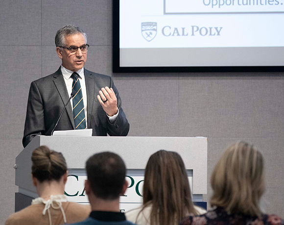 man speaking at podium in front of crowd